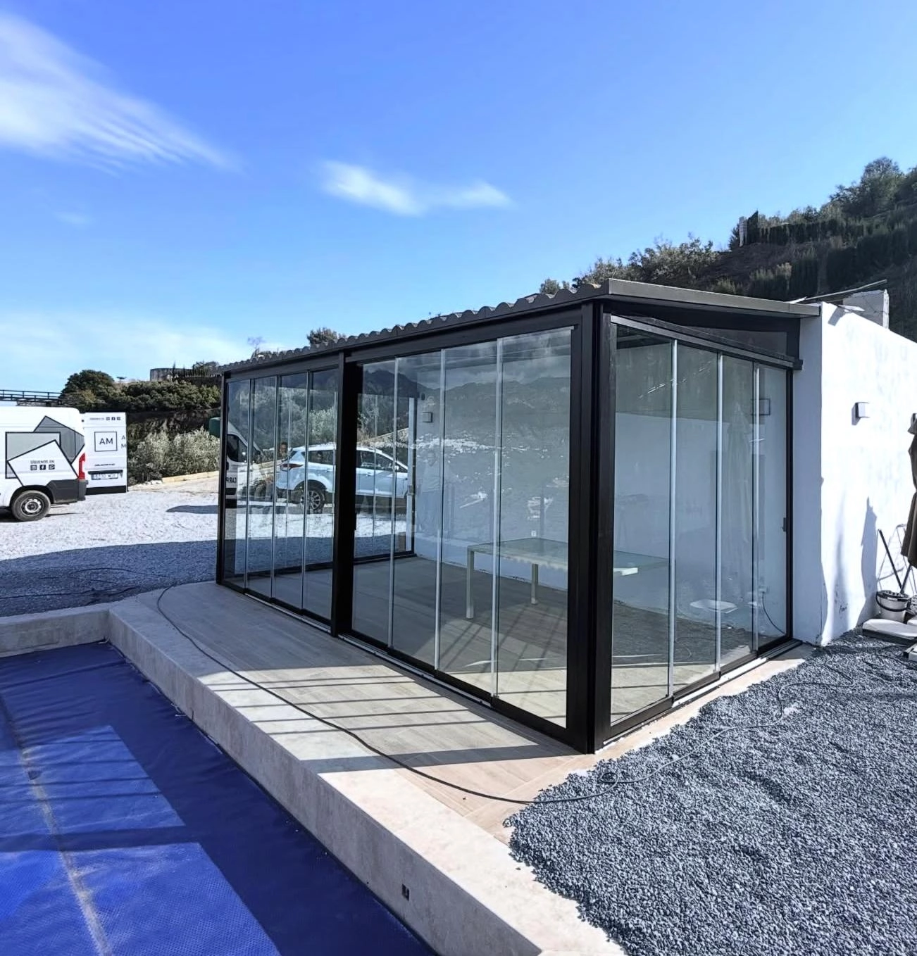Cortina de cristal con estructura de aluminio y techo panel imitación teja gris